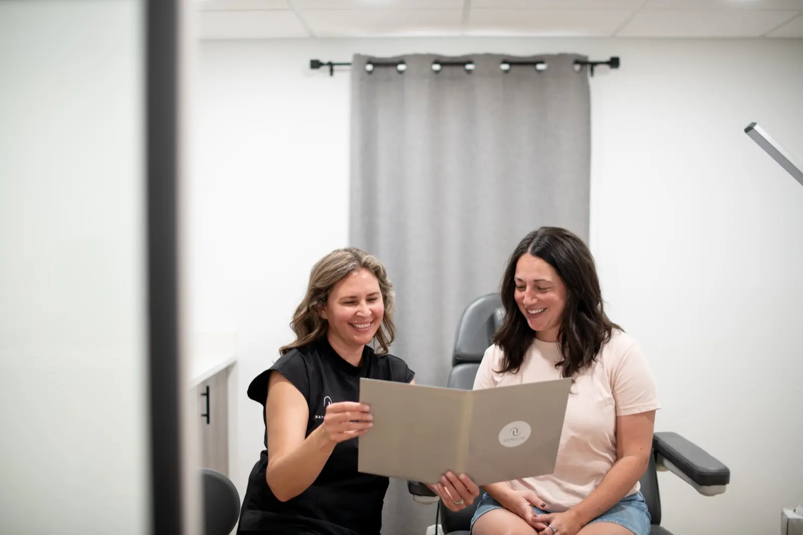 Tatiyana Stankovic reviewing a personalized treatment plan with a client at Naturally You