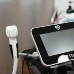 An Optimas machine with a handpiece used for laser treatments in a medical spa.