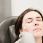 A woman receiving a cheek injection as part of a Botox treatment.