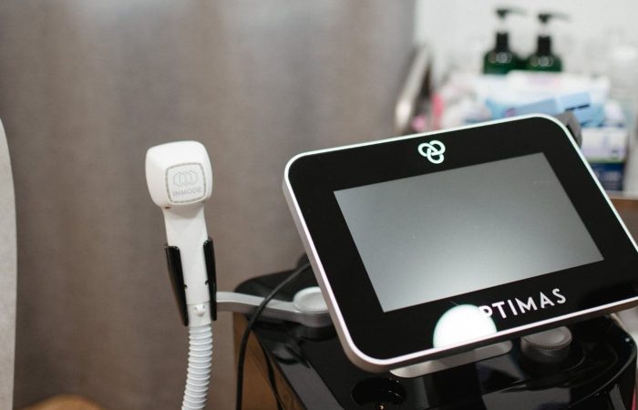 An Optimas machine with a handpiece used for laser treatments in a medical spa.