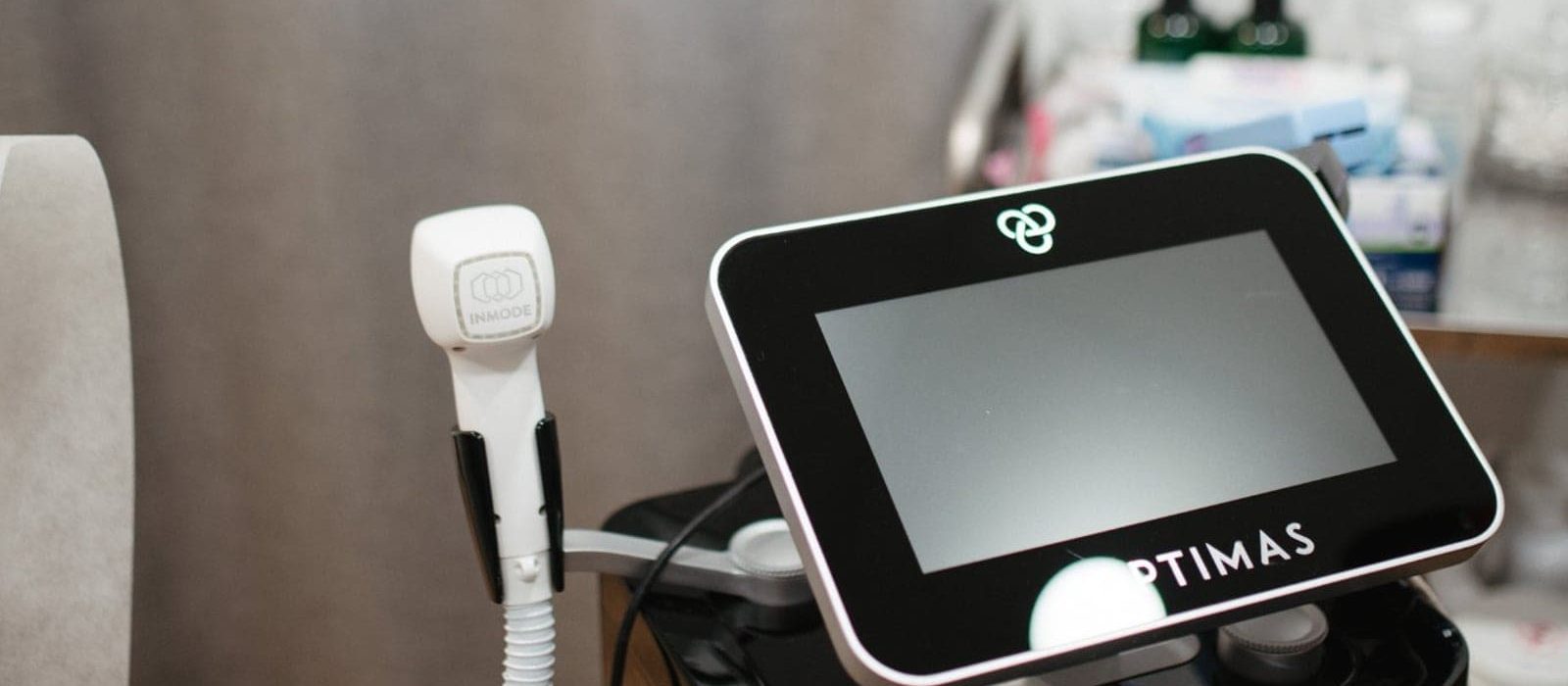 An Optimas machine with a handpiece used for laser treatments in a medical spa.
