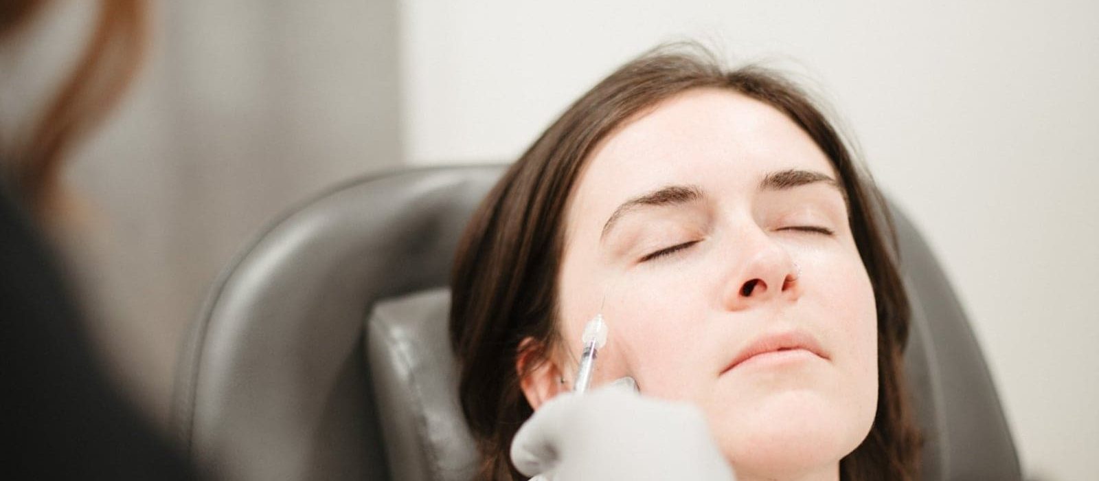 A woman receiving a cheek injection as part of a Botox treatment.